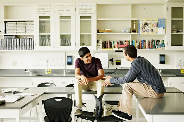 Two students sitting on desk in discussion in lab