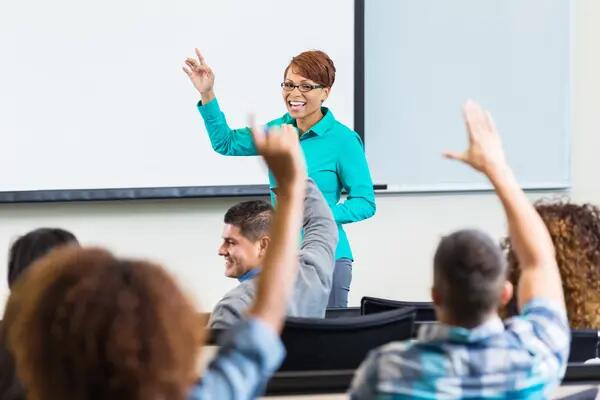 female professor taking questions after lecture in college classroom 