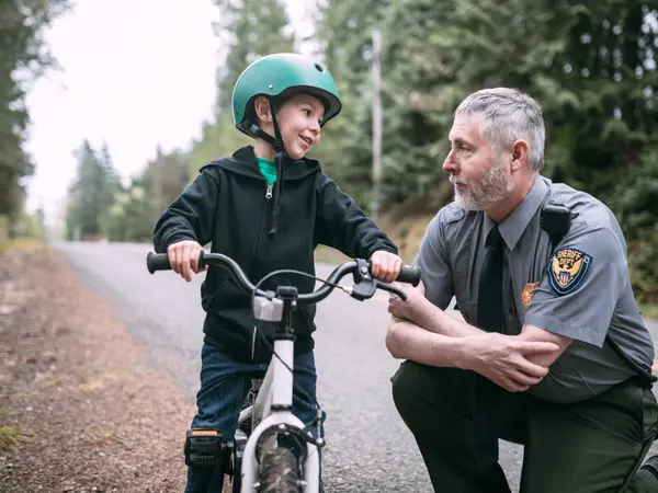 police office speaking with kid on bike